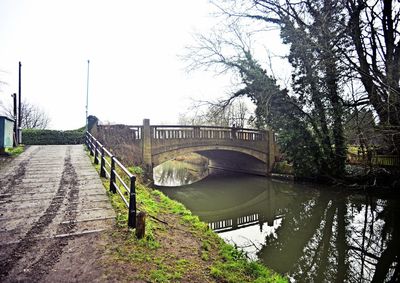 Footbridge over river against clear sky