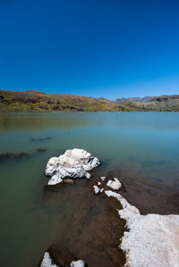 Scenic view of lake against clear blue sky