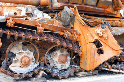 Torn caterpillars of a destroyed enemy rusty russian tank close-up.