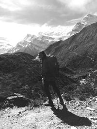 Portrait of woman standing on cliff against mountain