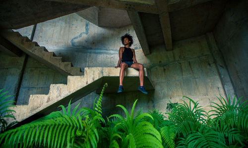 Full length of young woman sitting on steps