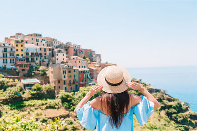 Rear view of woman looking at city against clear sky