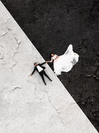 Directly above shot of bride and bridegroom lying on floor