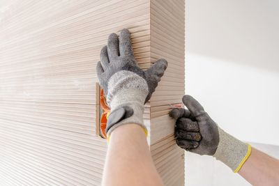 Cropped hands of person installing tiles