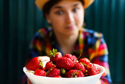 Midsection of woman holding strawberries