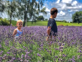 Full length of happy girl on flowers in field