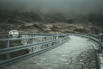 Bridge over mountains against sky during winter