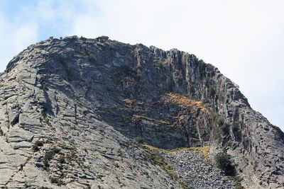 Low angle view of rocky mountain against sky