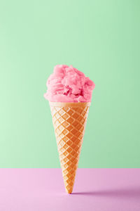 Pink ice cream cone against gray background