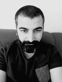 Portrait of young man against wall at home