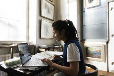 Side view of businesswoman using laptop at office