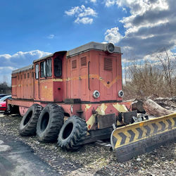 Abandoned truck on railroad track against sky