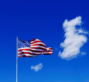 Low angle view of flag against blue sky