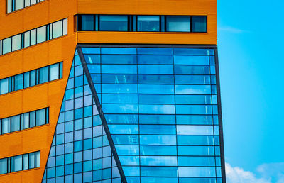 Low angle view of modern building against blue sky