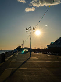 Street lights on footpath in city at sunset