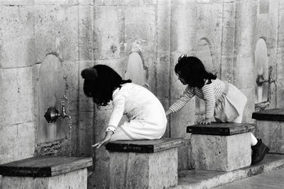 Side view of sisters washing hands