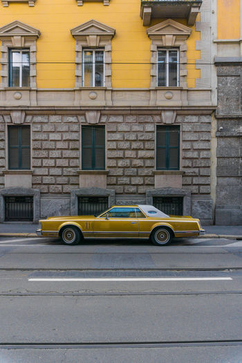 CAR ON STREET AGAINST BUILDINGS