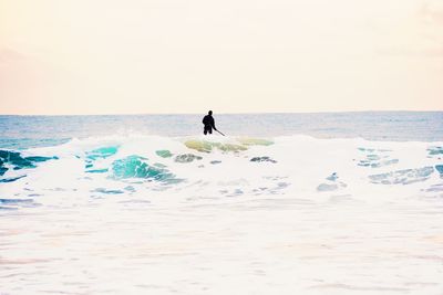 Man paddleboarding in sea