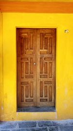 Close-up of closed door of yellow house