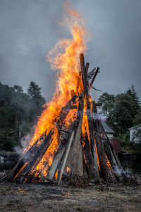 Bonfire on wooden structure against sky in summer