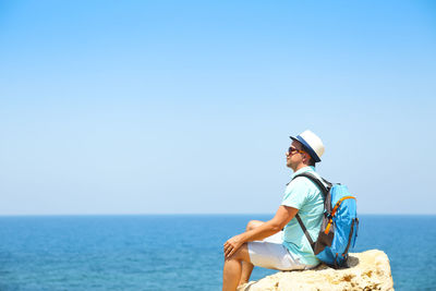 Man looking at sea against clear sky