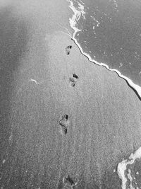 High angle view of footprints on sand at beach