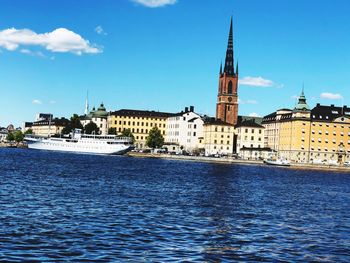 Buildings at waterfront against blue sky