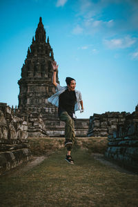 Full length of man jumping against historic building