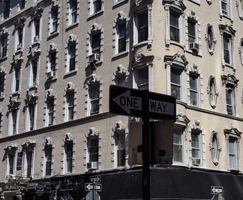 Low angle view of road sign against buildings