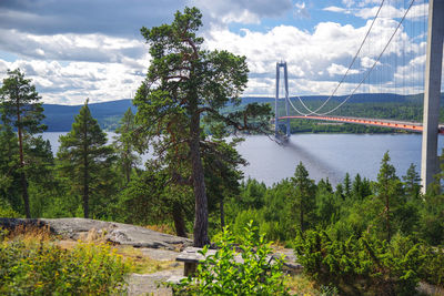 Bridge over river against cloudy sky