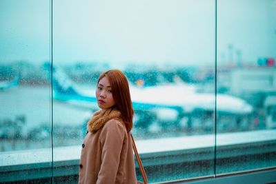 Young woman standing against sky