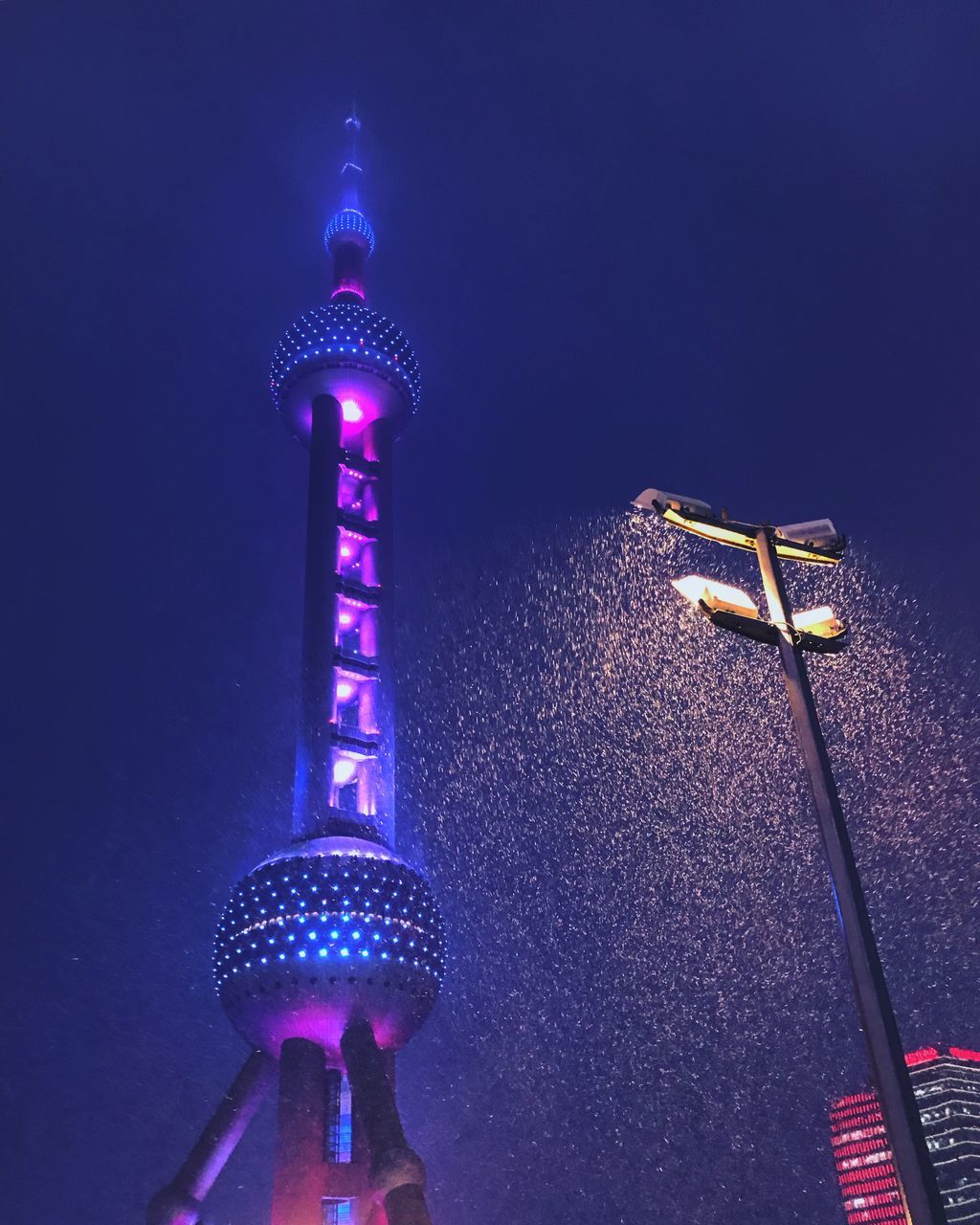 LOW ANGLE VIEW OF ILLUMINATED CITY AGAINST BLUE SKY