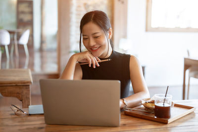 Young woman using laptop at table