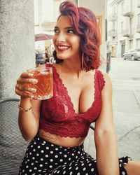 Portrait of a smiling young woman drinking glass