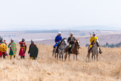 People enjoying on land against sky