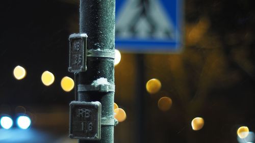 Close-up of information sign during winter at night