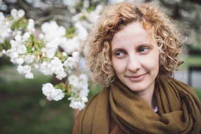 Woman looking away against blooming flowers