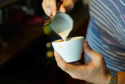 Midsection of man holding coffee cup