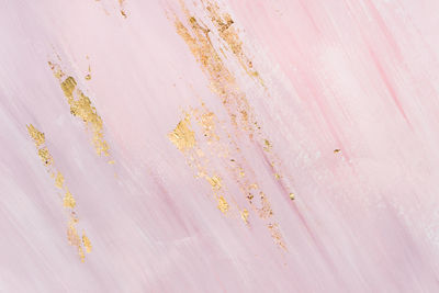 Delicate pink marble background with gold brushstrokes. place for your design.