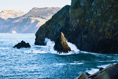 Rock formation in sea against sky