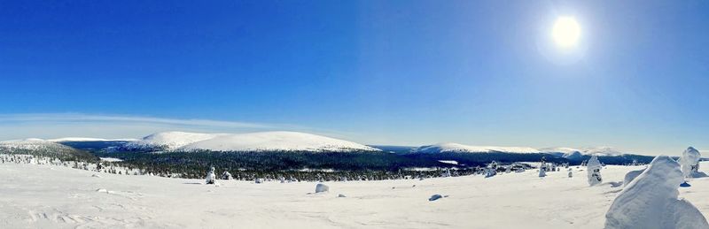Panoramic view of snowcapped mountains against blue sky