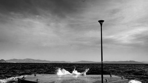 Street light on beach against sky