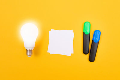 Close-up of light bulb against yellow background