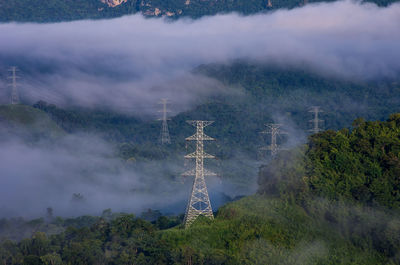 Aerial view of communications tower and trees against sky