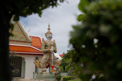 Statue in temple against sky