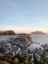 High angle view of city by sea against sky