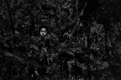 Young woman hiding in forest