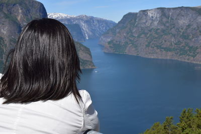 Rear view of woman looking at lake and mountains