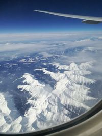 Aerial view of clouds over landscape seen from airplane window