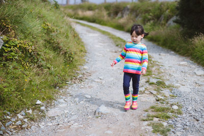 Young girl walking on summer countryside road